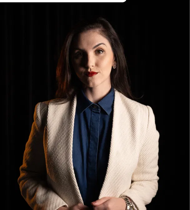 Retrato corporativo da sócia Maria em blazer bege e camisa azul.